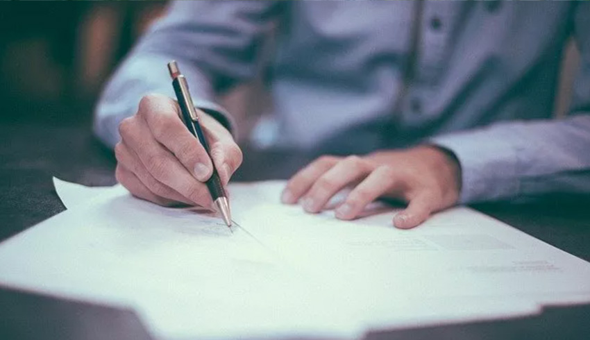 Executive signs paperwork with a fountain pen