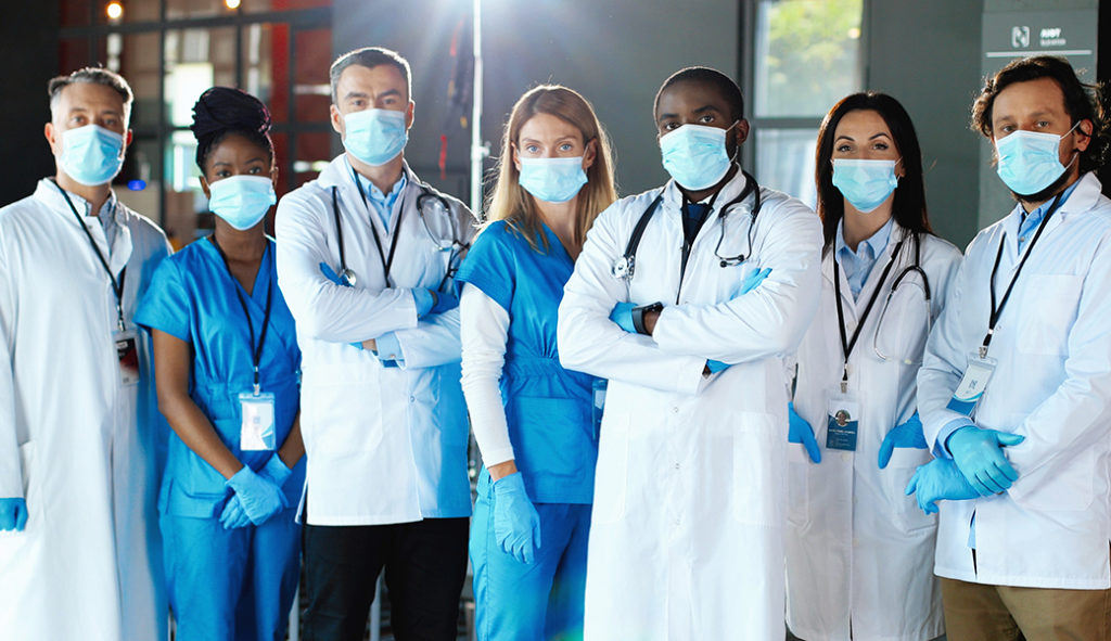 Masked team of nurse practitioners, physician assistants, and doctors