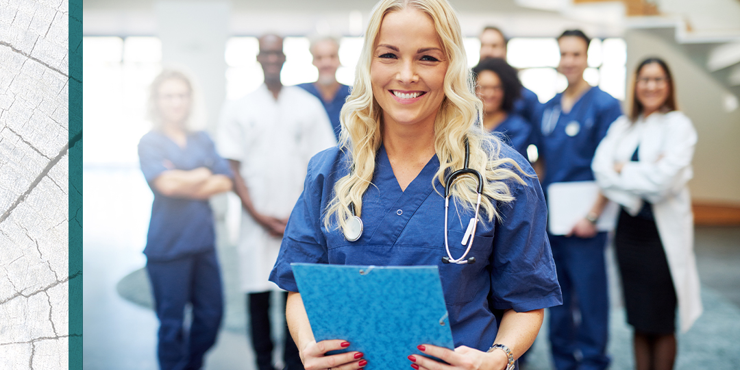Female nurse practitioner stands in front of medical team