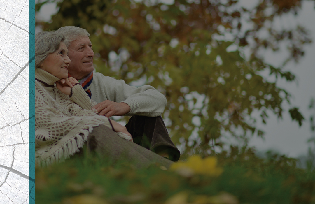 Senior couple sitting on the grass enjoying the weather